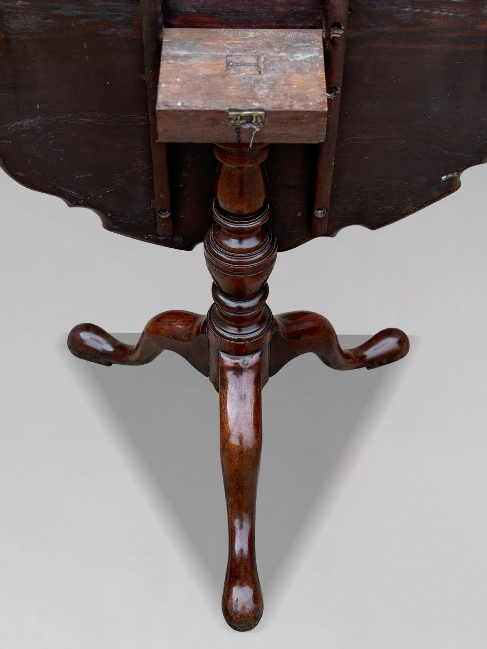 An 18th-century George III mahogany tilt-top tripod table shown in the vertical position with a carved pie-crust rim, turned pedestal, and cabriole legs. View III