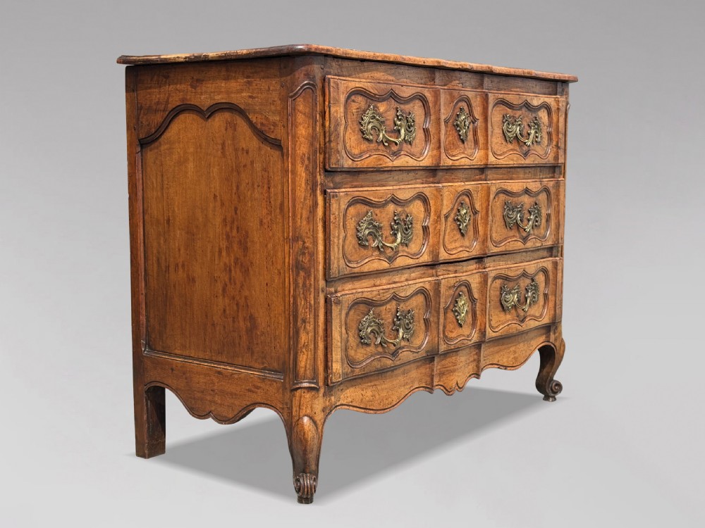 An eighteenth-century French Louis XV walnut commode featuring three carved drawers with rococo brass handles and cabriole legs. View XIII