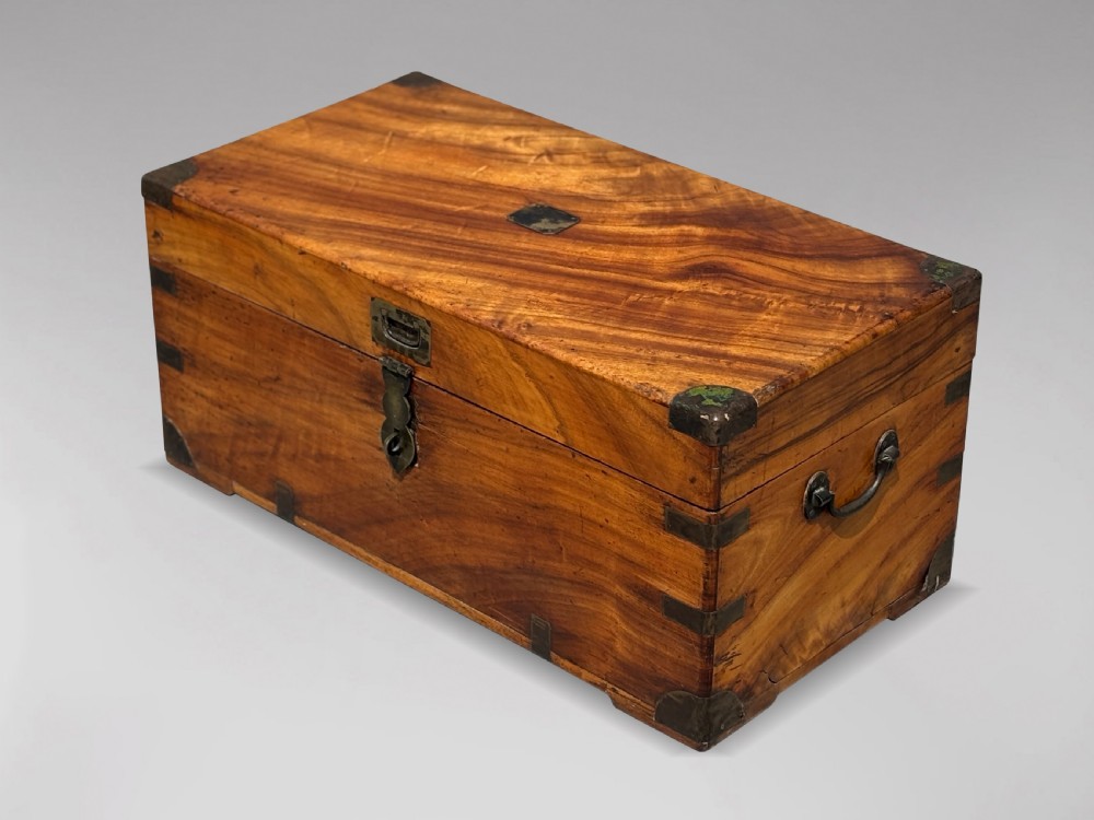 A 19th-century rectangular camphor wood campaign trunk with brass corner fittings and side carrying handles.