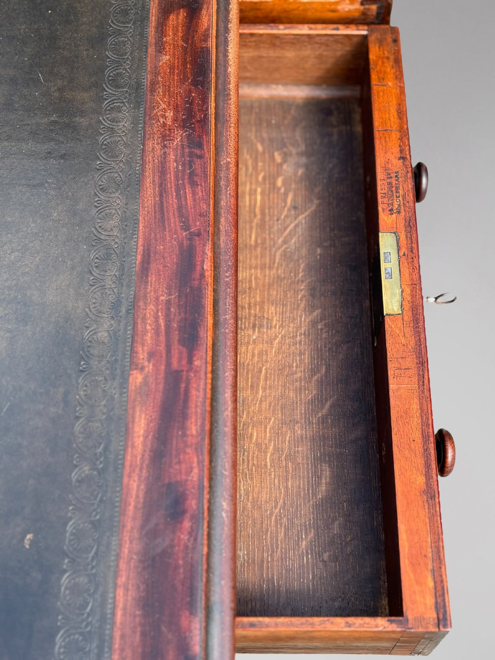 An 18th-century mahogany library table featuring a black leather top insert, frieze drawers with wooden knob handles, and turned, fluted legs on brass castors. View VIII