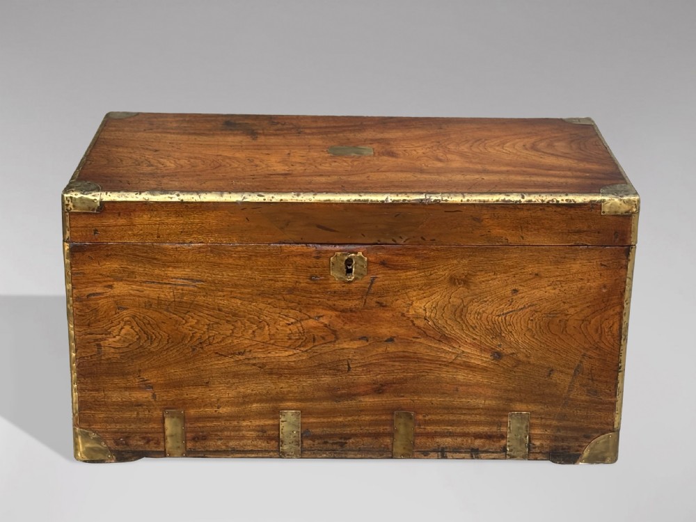 A rectangular 19th-century camphor wood campaign trunk with brass corner strapping, edge binding, a central flush plaque, and iron side handles. View II