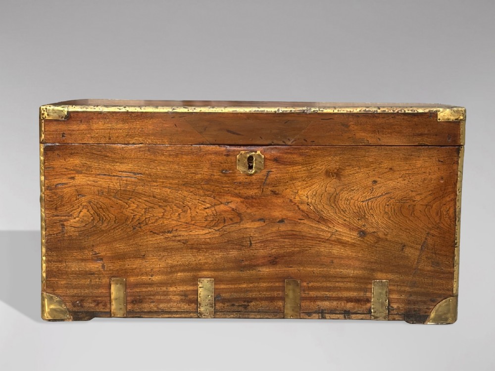 A rectangular 19th-century camphor wood campaign trunk with brass corner strapping, edge binding, a central flush plaque, and iron side handles. View IV