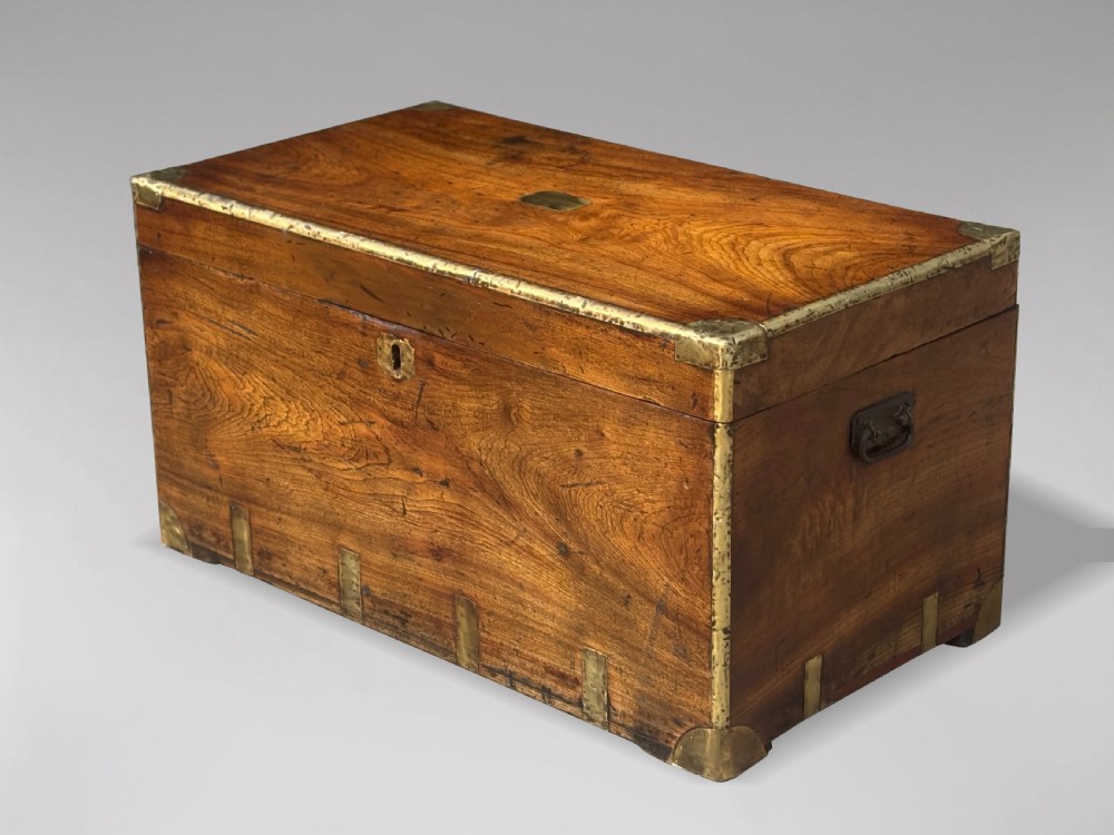 A rectangular 19th-century camphor wood campaign trunk with brass corner strapping, edge binding, a central flush plaque, and iron side handles. View X