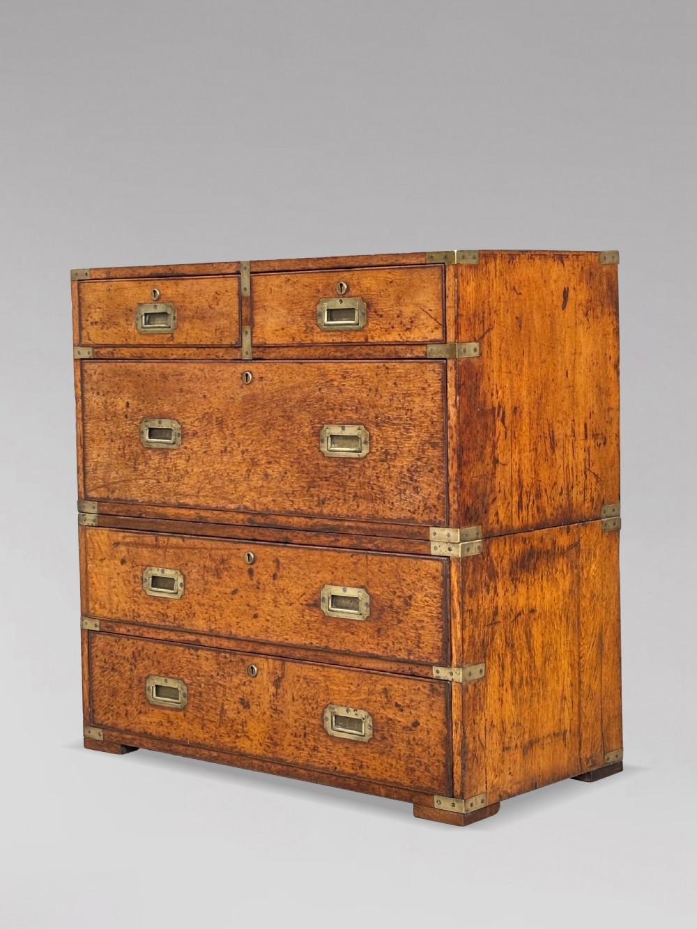 A nineteenth-century oak military campaign chest of drawers featuring brass corner straps, recessed flush handles, and turned feet. View VI