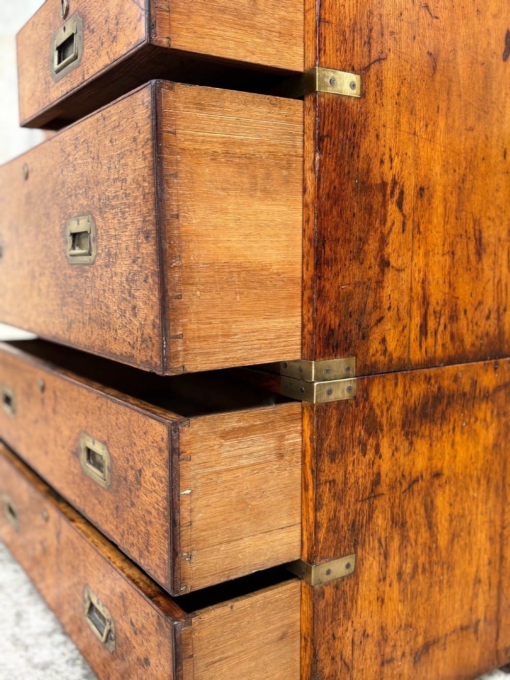 A nineteenth-century oak military campaign chest of drawers featuring brass corner straps, recessed flush handles, and turned feet. View VII