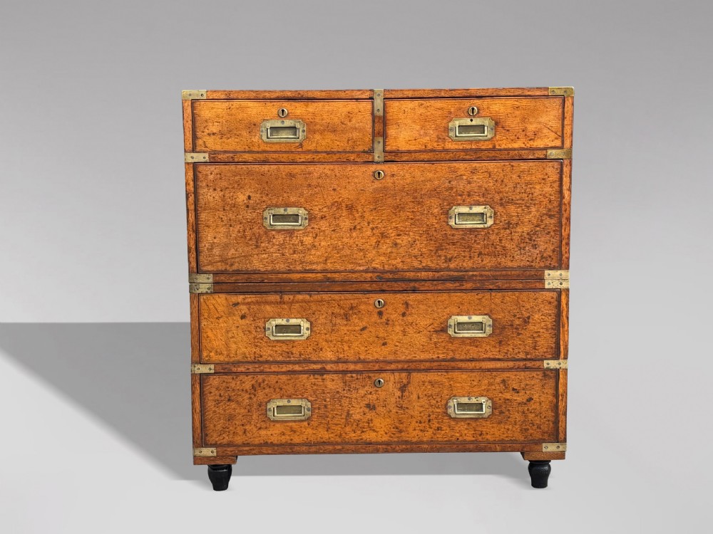 A nineteenth-century oak military campaign chest of drawers featuring brass corner straps, recessed flush handles, and turned feet. View X