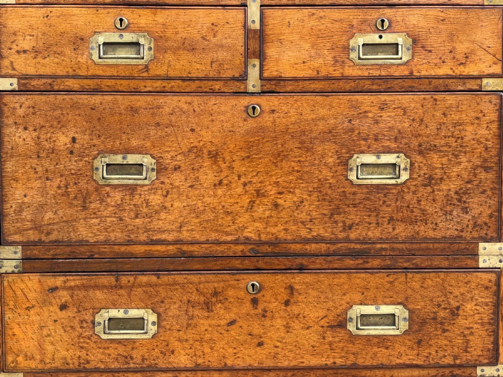 A nineteenth-century oak military campaign chest of drawers featuring brass corner straps, recessed flush handles, and turned feet. View XIII