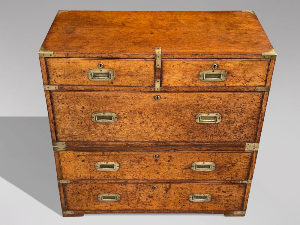 A nineteenth-century oak military campaign chest of drawers featuring brass corner straps, recessed flush handles, and turned feet. View XVII