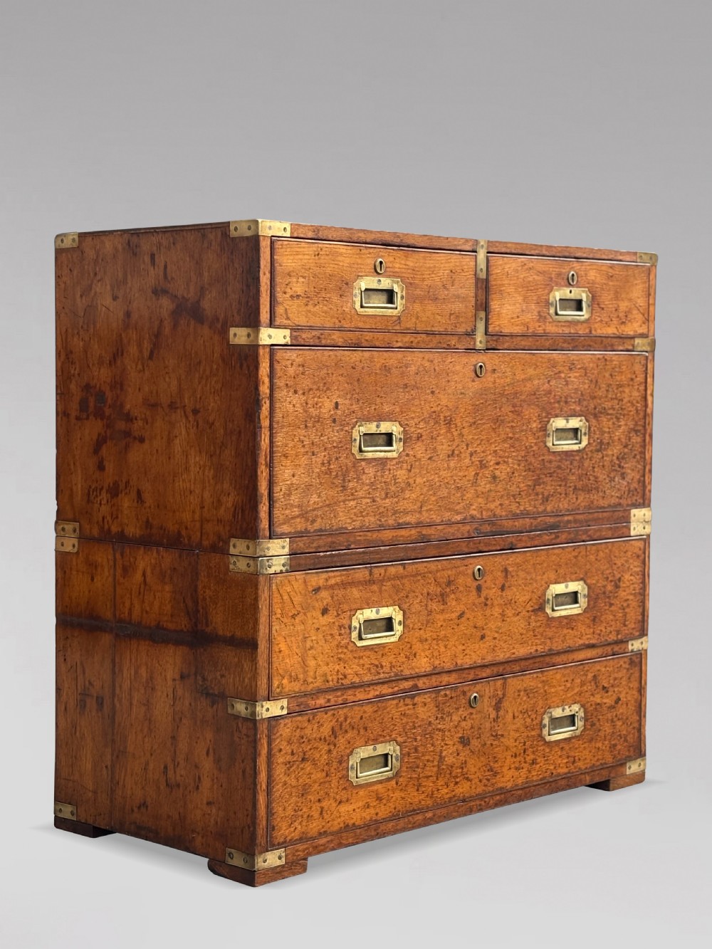 A nineteenth-century oak military campaign chest of drawers featuring brass corner straps, recessed flush handles, and turned feet. View XIX