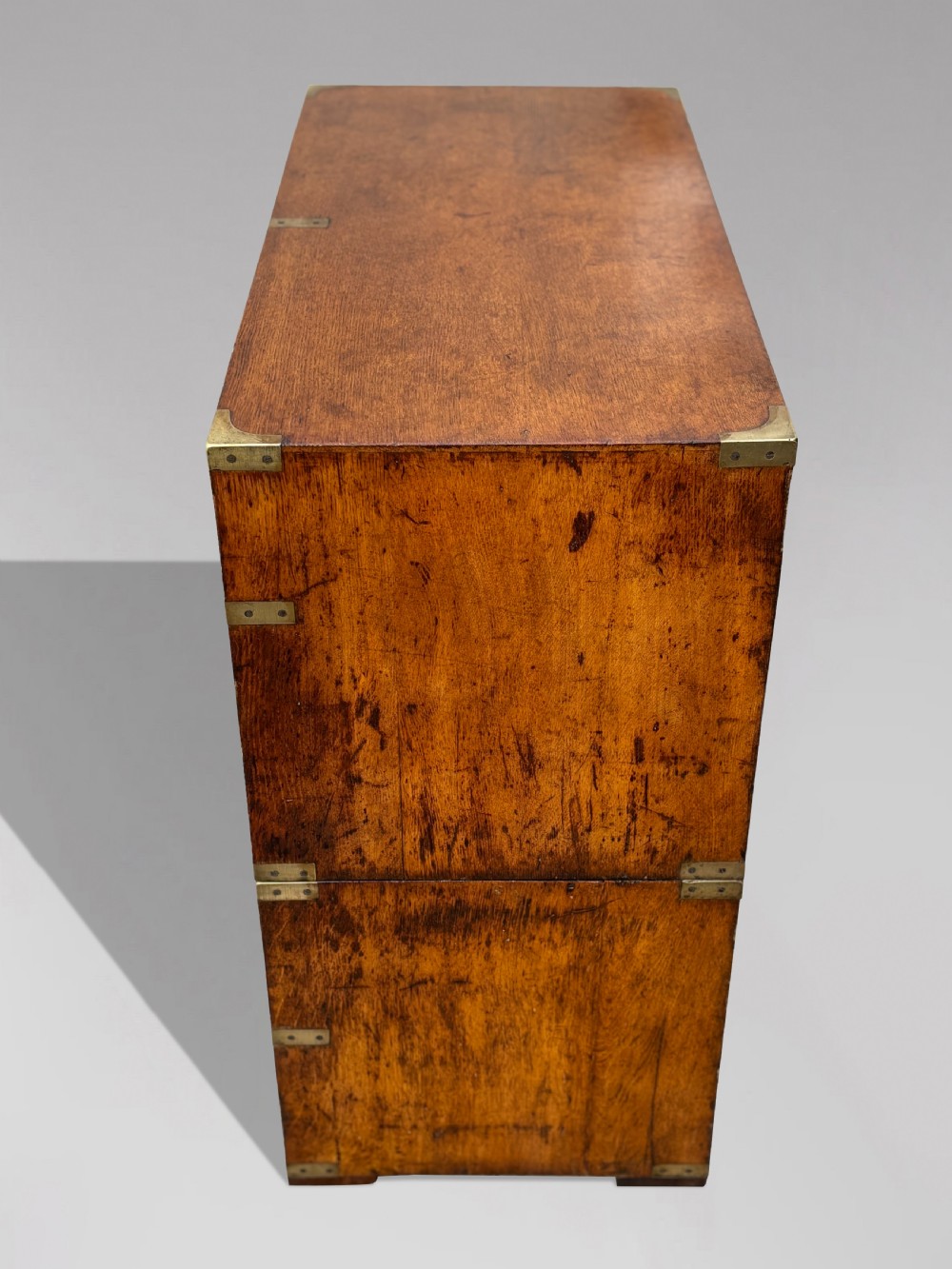 A nineteenth-century oak military campaign chest of drawers featuring brass corner straps, recessed flush handles, and turned feet. View XX
