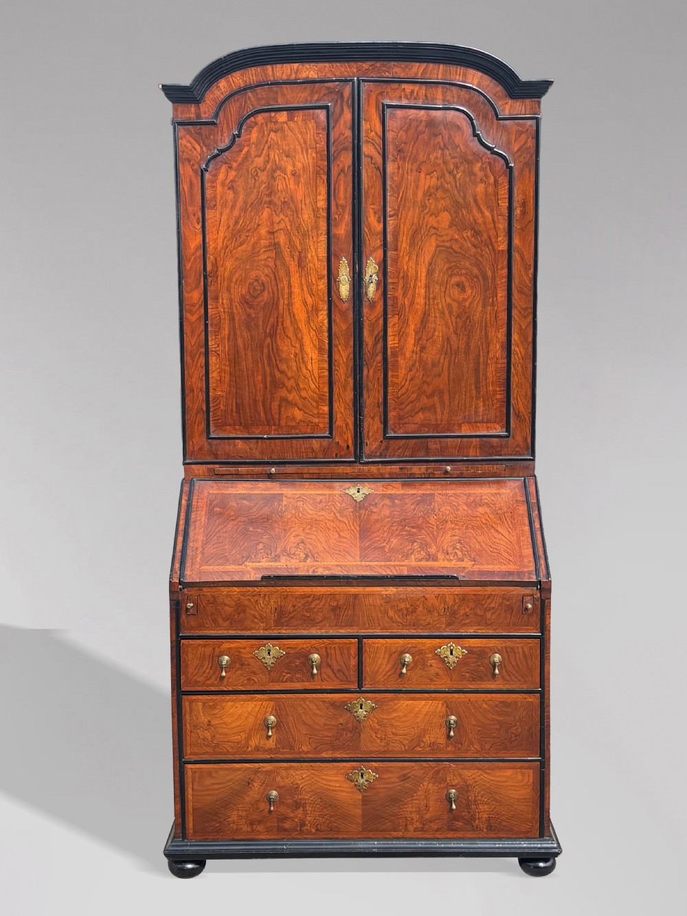 An 18th-century George I walnut bureau bookcase featuring arched panelled upper doors, a slant-front desk, and graduated lower drawers. View II