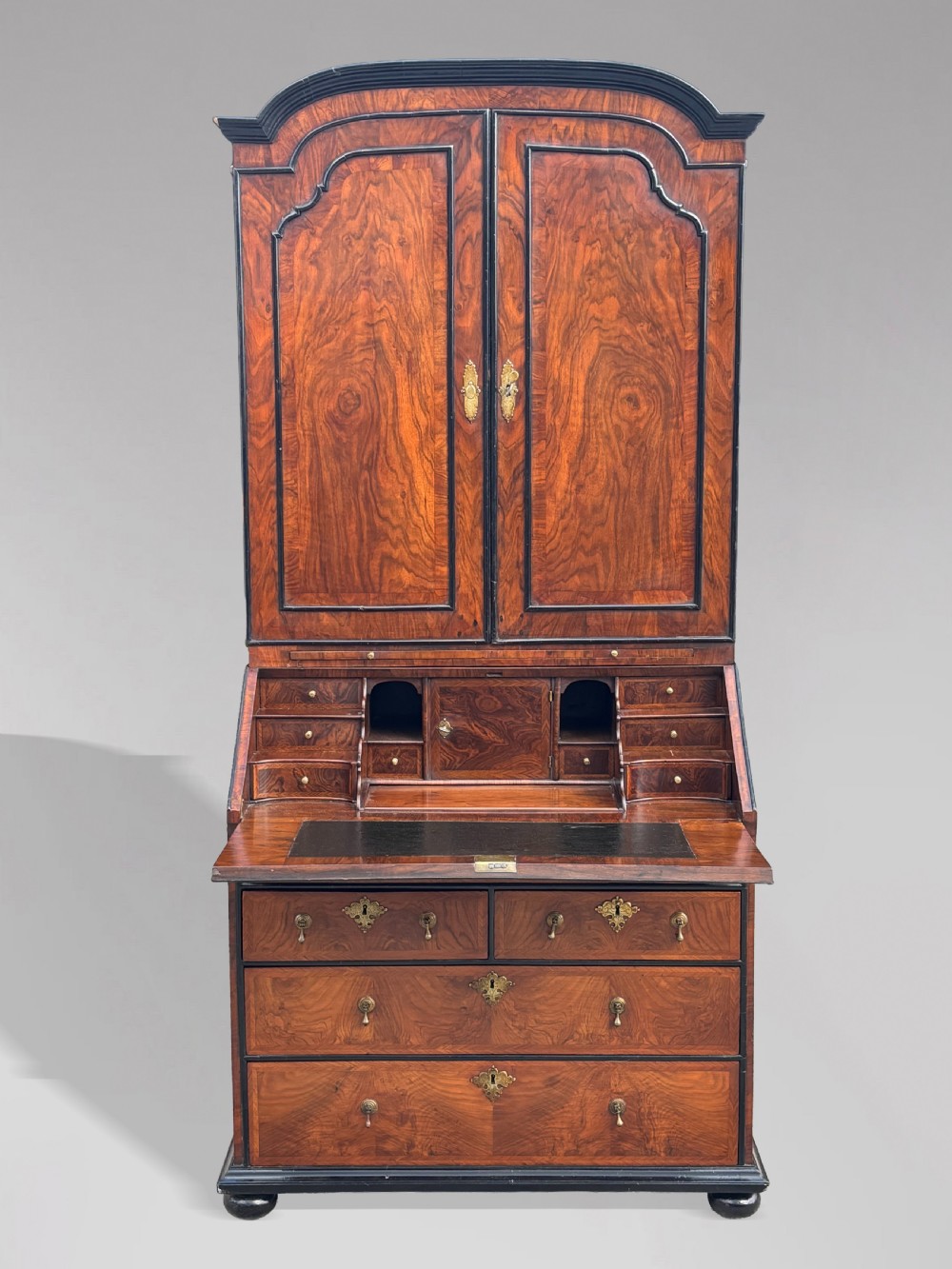 An 18th-century George I walnut bureau bookcase featuring arched panelled upper doors, a slant-front desk, and graduated lower drawers. View III