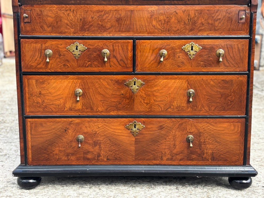 An 18th-century George I walnut bureau bookcase featuring arched panelled upper doors, a slant-front desk, and graduated lower drawers. View V
