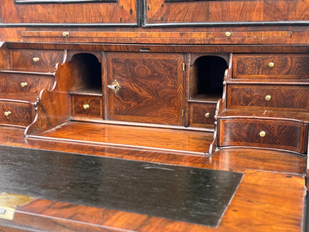 An 18th-century George I walnut bureau bookcase featuring arched panelled upper doors, a slant-front desk, and graduated lower drawers. View VIII