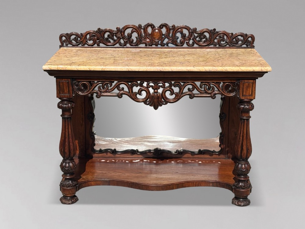 A 19th-century carved rosewood console table featuring a light marble top, elaborate pierced scrollwork frieze, mirrored back panel, and a shaped lower shelf. View II