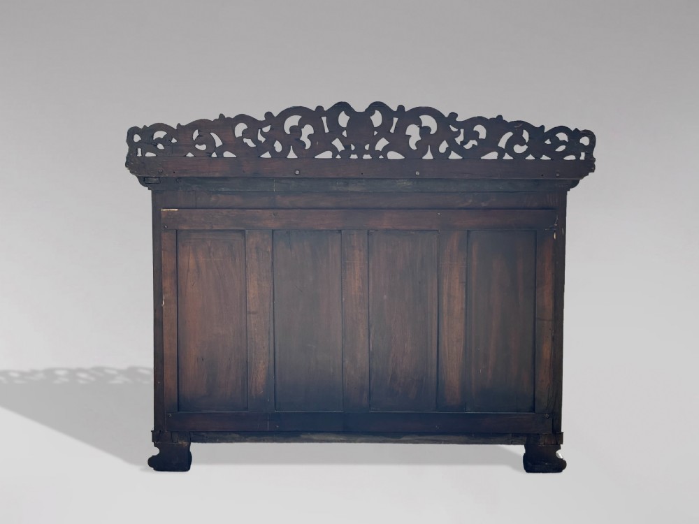 A 19th-century carved rosewood console table featuring a light marble top, elaborate pierced scrollwork frieze, mirrored back panel, and a shaped lower shelf. View IV