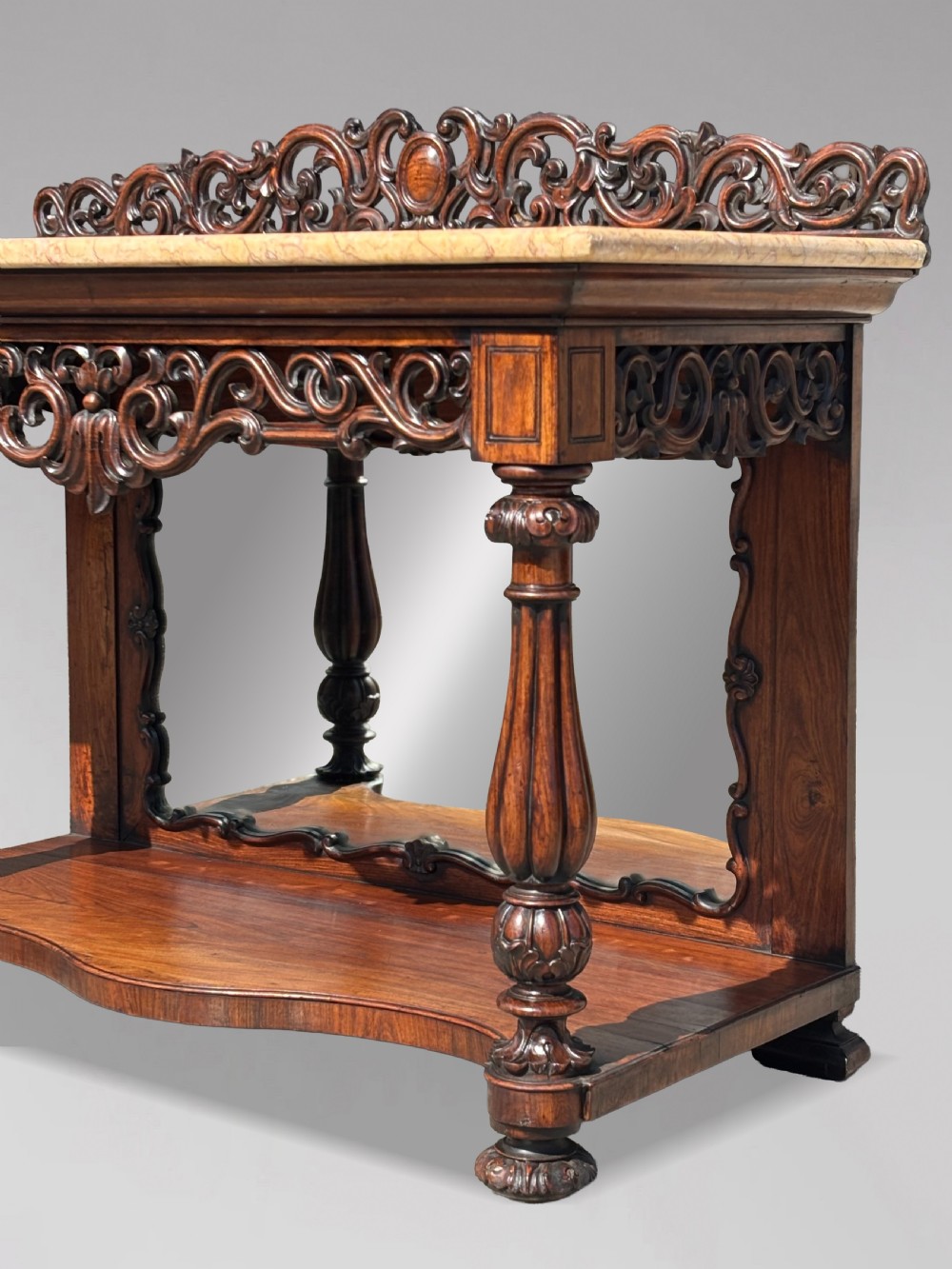 A 19th-century carved rosewood console table featuring a light marble top, elaborate pierced scrollwork frieze, mirrored back panel, and a shaped lower shelf. View VIII