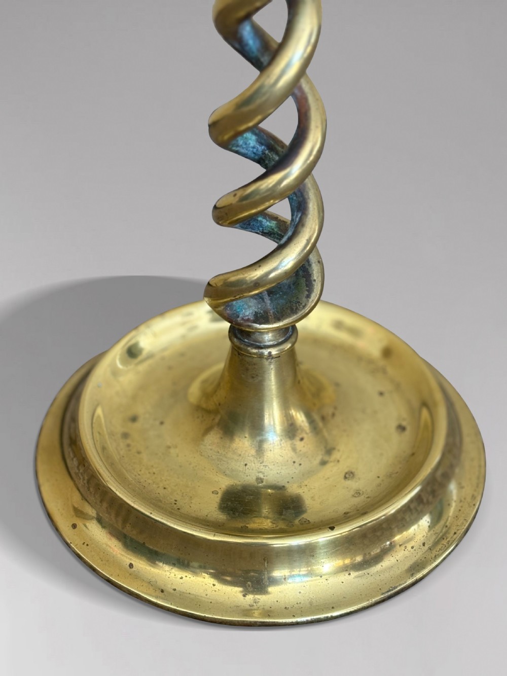 A pair of tall Victorian brass candlesticks featuring open barley twist stems and circular stepped bases. View II