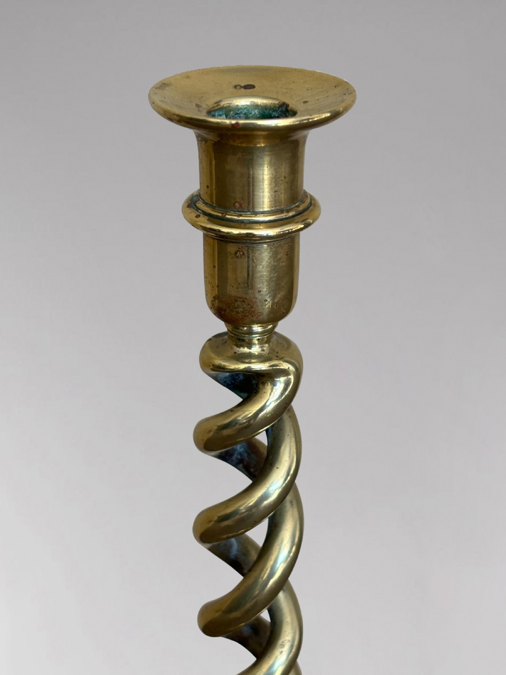 A pair of tall Victorian brass candlesticks featuring open barley twist stems and circular stepped bases. View III