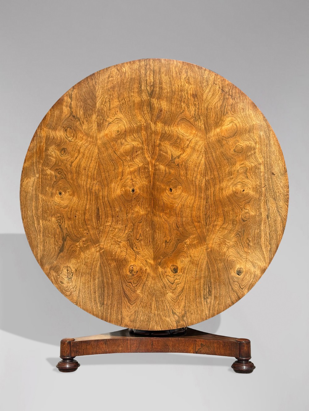 An early 19th-century William IV circular tilt-top centre table constructed from figured rosewood with a triform base.