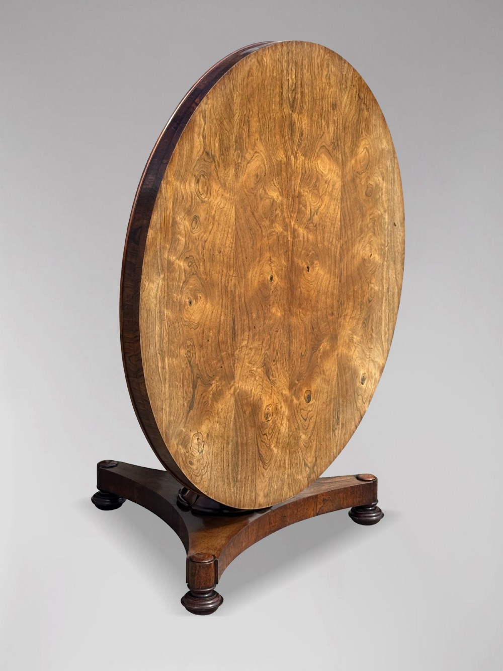 An early 19th-century William IV circular tilt-top centre table constructed from figured rosewood with a triform base. View IV