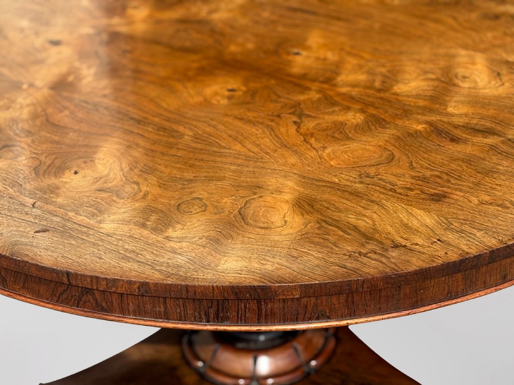 An early 19th-century William IV circular tilt-top centre table constructed from figured rosewood with a triform base. View X