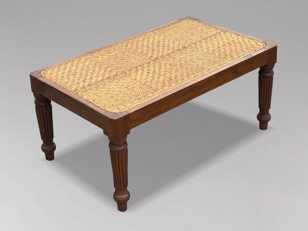 A 19th-century rectangular teak stool with fluted turned legs and a cream textured upholstered cushion top. View III