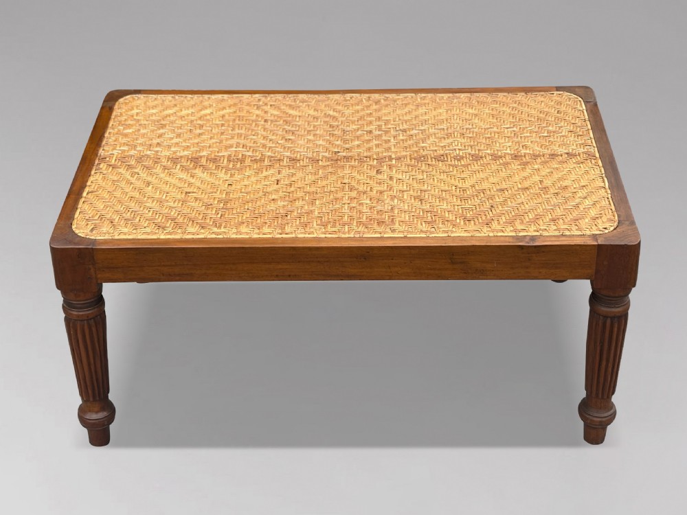 A 19th-century rectangular teak stool with fluted turned legs and a cream textured upholstered cushion top. View V