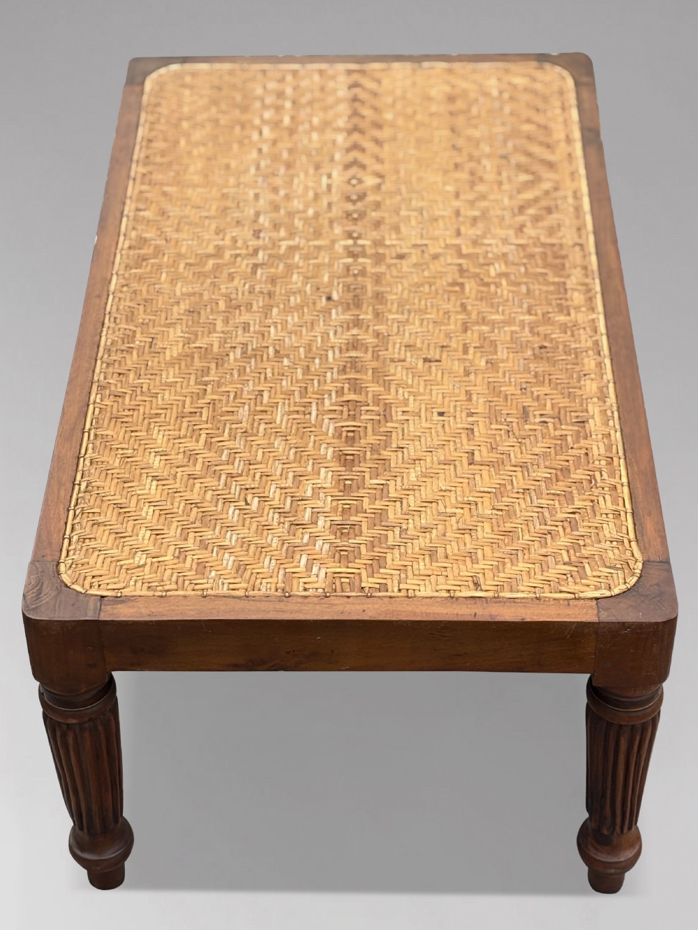 A 19th-century rectangular teak stool with fluted turned legs and a cream textured upholstered cushion top. View VII