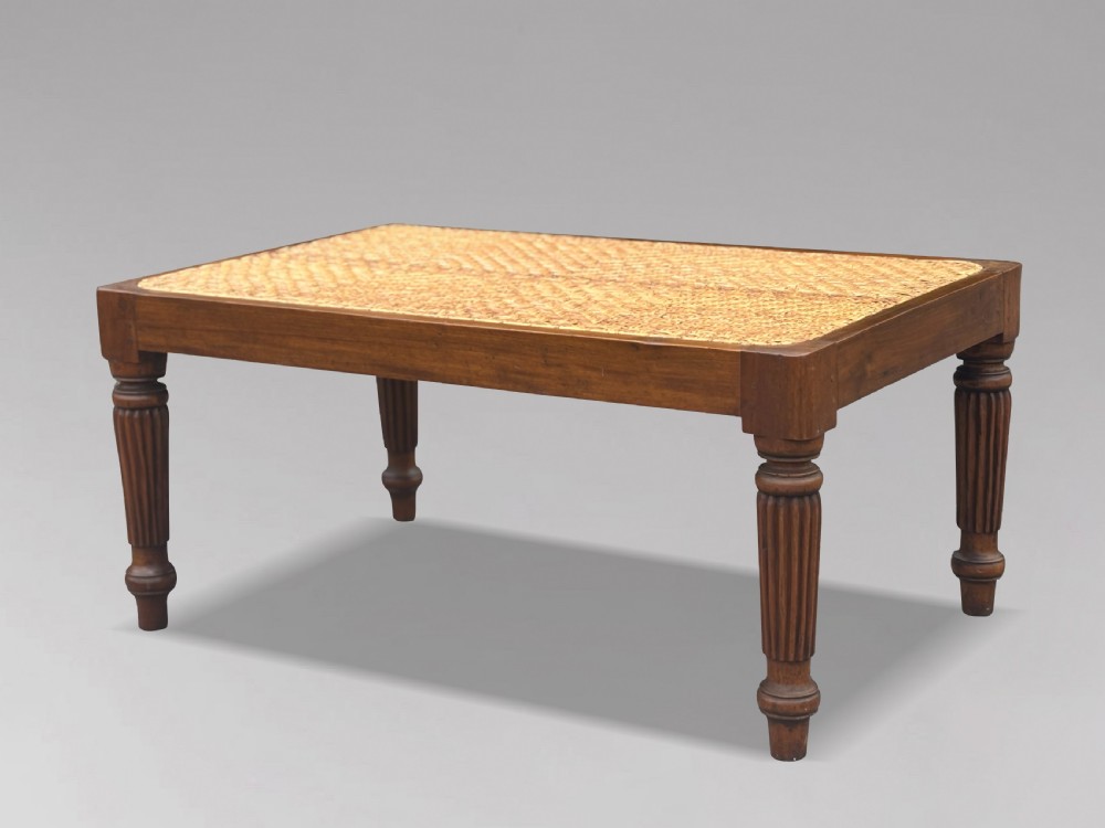 A 19th-century rectangular teak stool with fluted turned legs and a cream textured upholstered cushion top. View IX