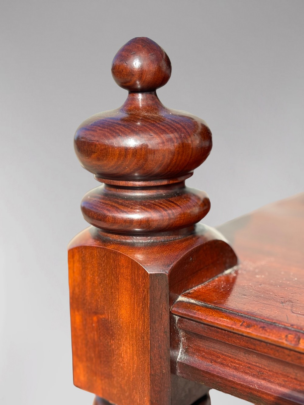 A nineteenth-century three-tiered mahogany dumb waiter with turned support columns, two drawers at the base, and brass castors. View IX