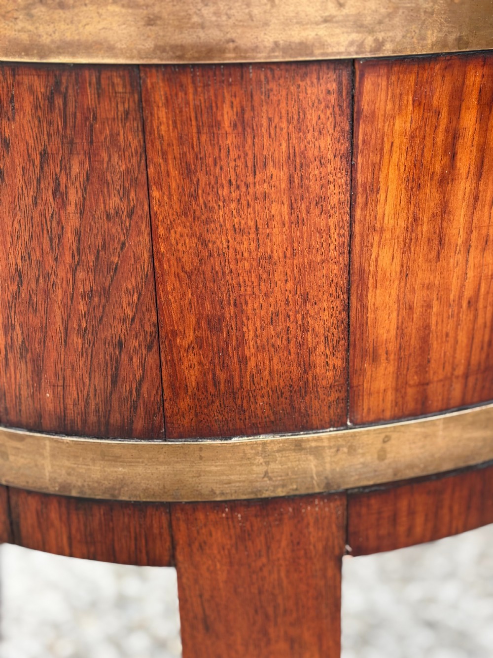An 18th-century George III oval staved walnut wine cooler featuring twin brass binding bands, splayed legs, and an internal metal liner. View VI