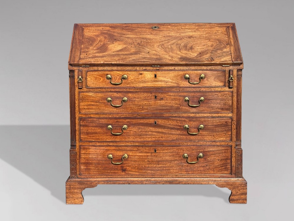 An 18th-century George III mahogany bureau featuring a sloping fall-front writing flap above four graduated drawers with brass handles and bracket feet. View II
