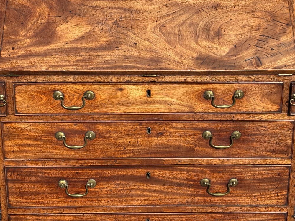 An 18th-century George III mahogany bureau featuring a sloping fall-front writing flap above four graduated drawers with brass handles and bracket feet. View III