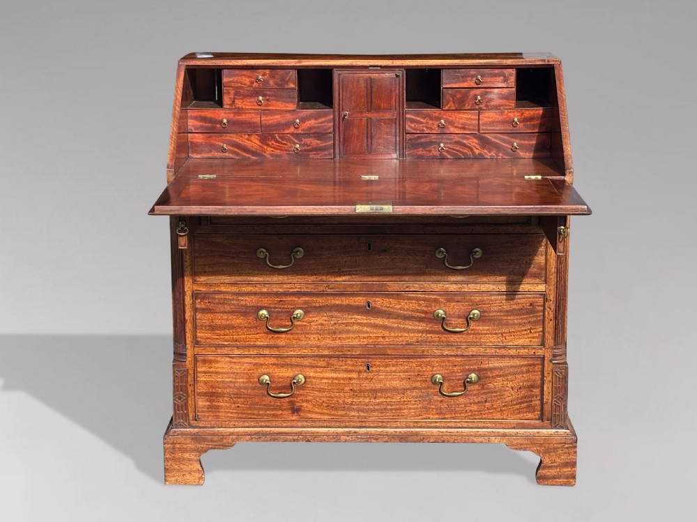 An 18th-century George III mahogany bureau featuring a sloping fall-front writing flap above four graduated drawers with brass handles and bracket feet. View VI