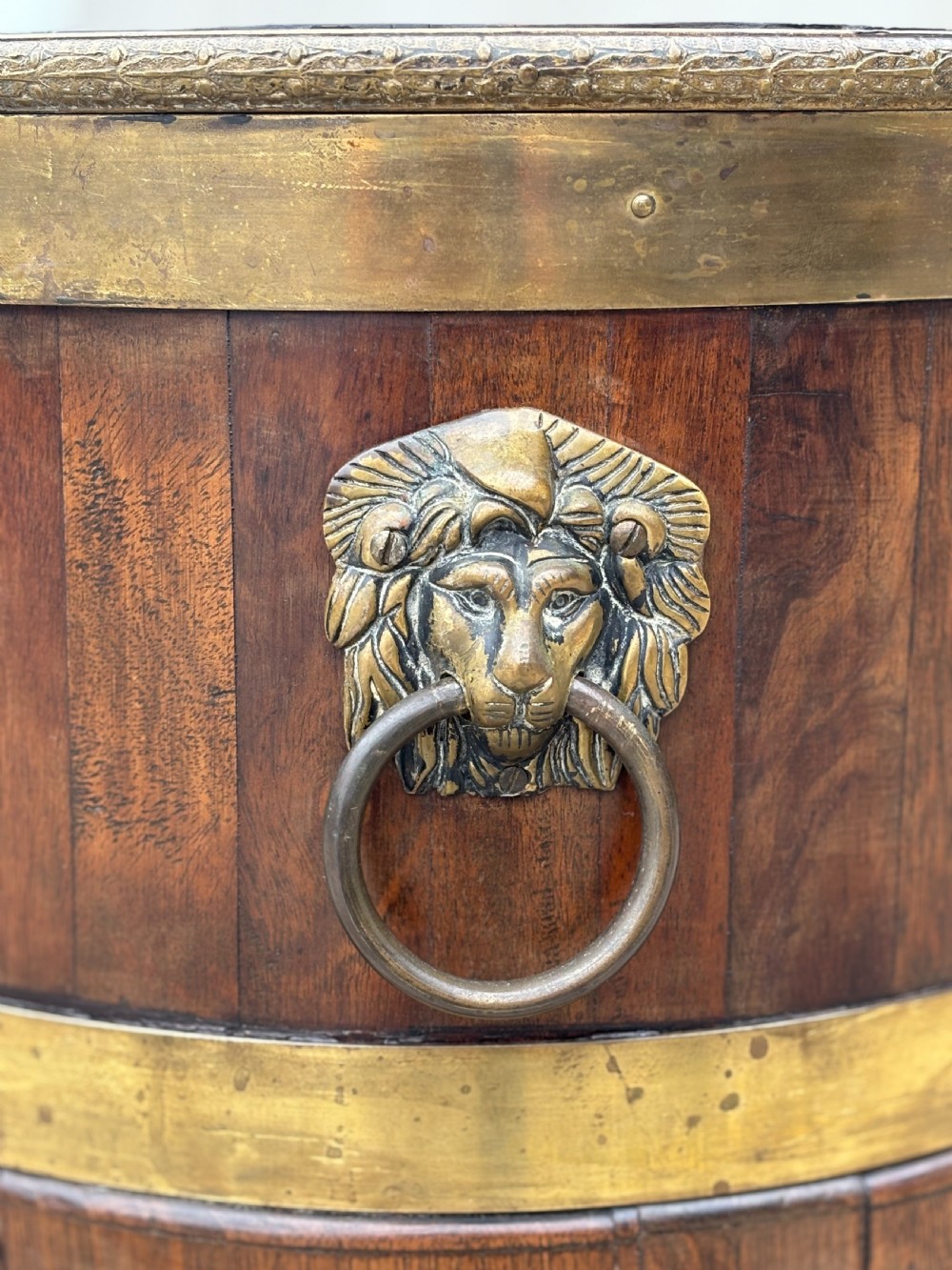 A pair of oval eighteenth-century Georgian mahogany wine coolers featuring brass banding, lion mask drop handles, metal liners, and cabriole legs. View V