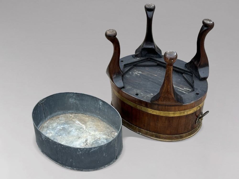 A pair of oval eighteenth-century Georgian mahogany wine coolers featuring brass banding, lion mask drop handles, metal liners, and cabriole legs. View VIII