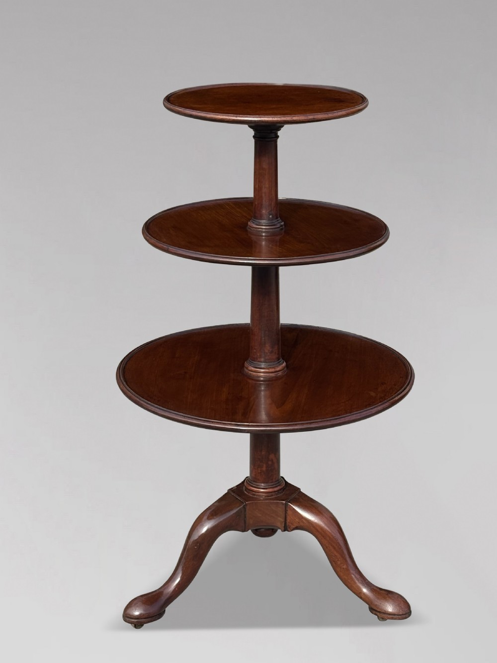 An 18th-century George III mahogany dumb waiter featuring three graduated circular tiers supported by turned columns on a tripod base.