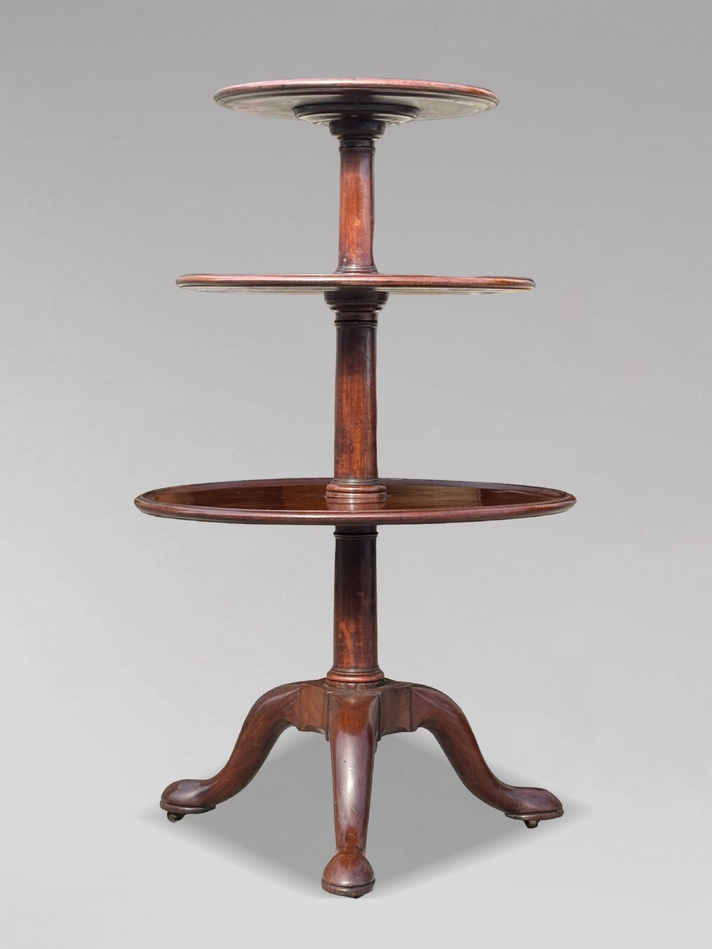 An 18th-century George III mahogany dumb waiter featuring three graduated circular tiers supported by turned columns on a tripod base. View X