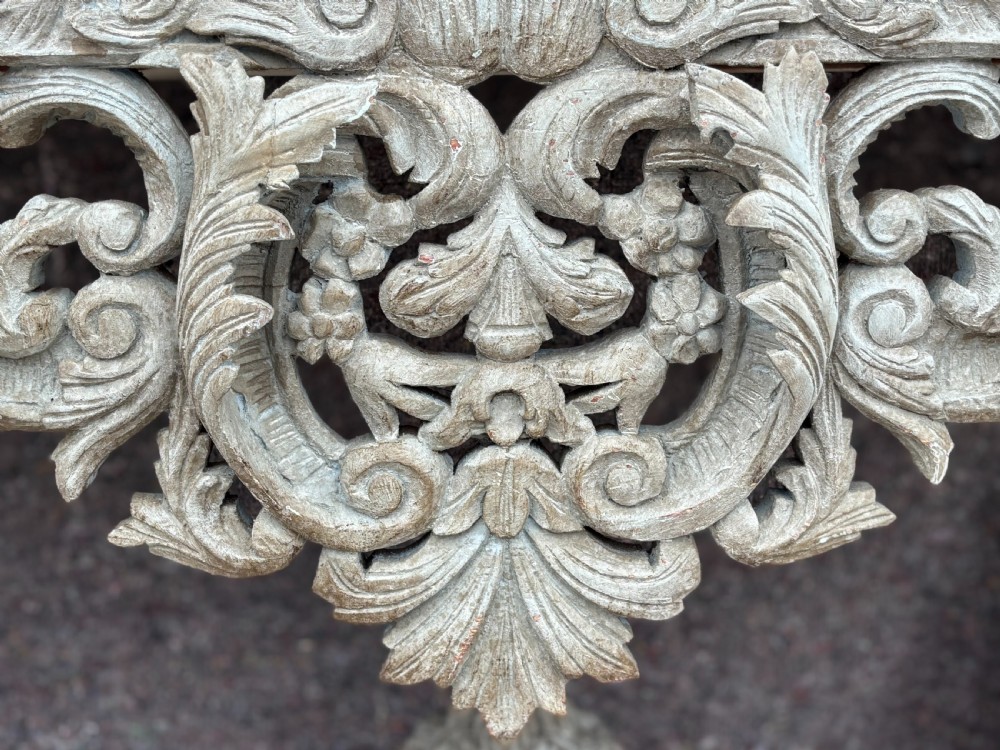 A carved Louis XIV style grey painted console table with an intricate aproned skirt, stretcher base, and faux marble top. View IV