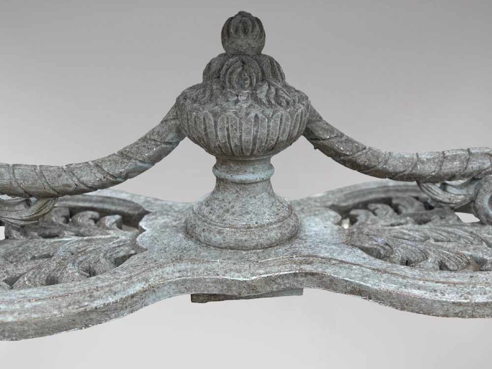 A carved Louis XIV style grey painted console table with an intricate aproned skirt, stretcher base, and faux marble top. View V