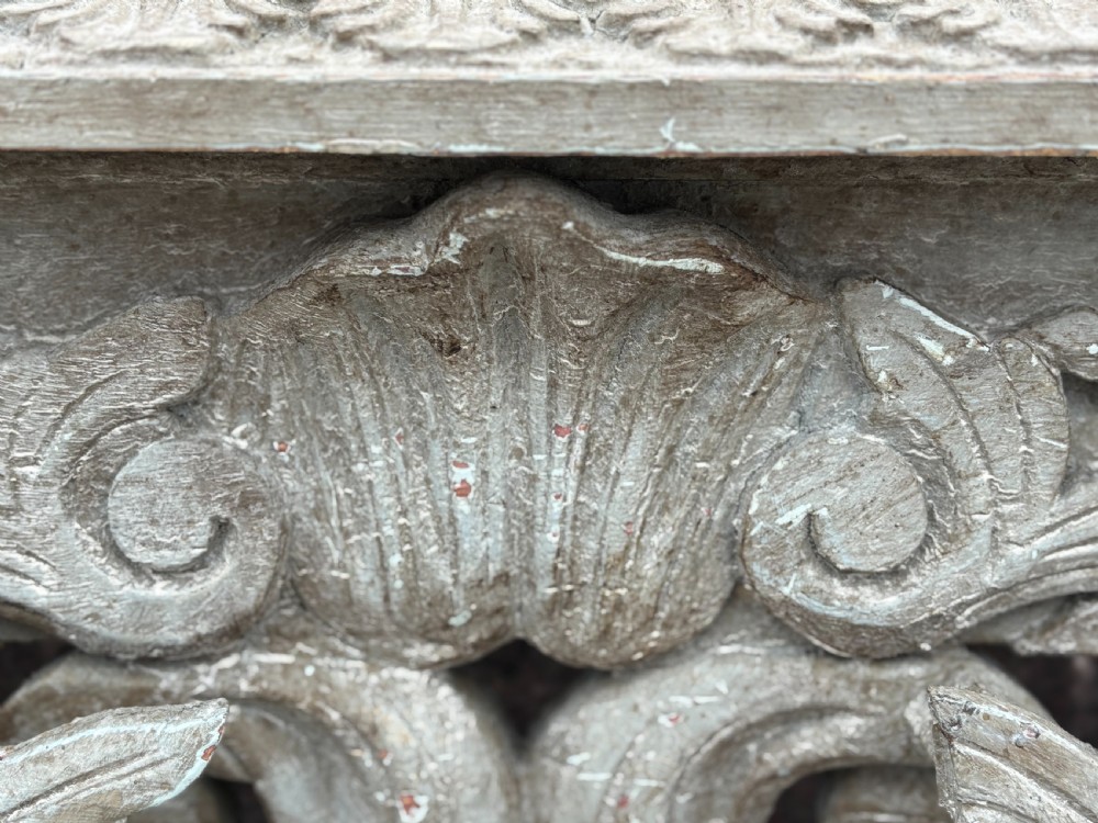 A carved Louis XIV style grey painted console table with an intricate aproned skirt, stretcher base, and faux marble top. View VI