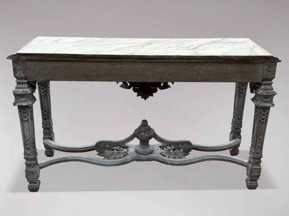 A carved Louis XIV style grey painted console table with an intricate aproned skirt, stretcher base, and faux marble top. View VII