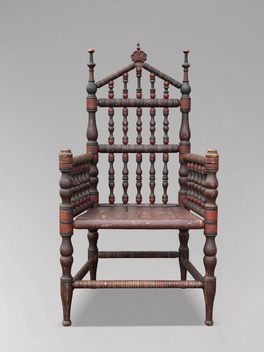 A 19th-century Swedish country throne armchair constructed with polychrome turned bobbins, a carved crown top finial, and a light cushion. View III