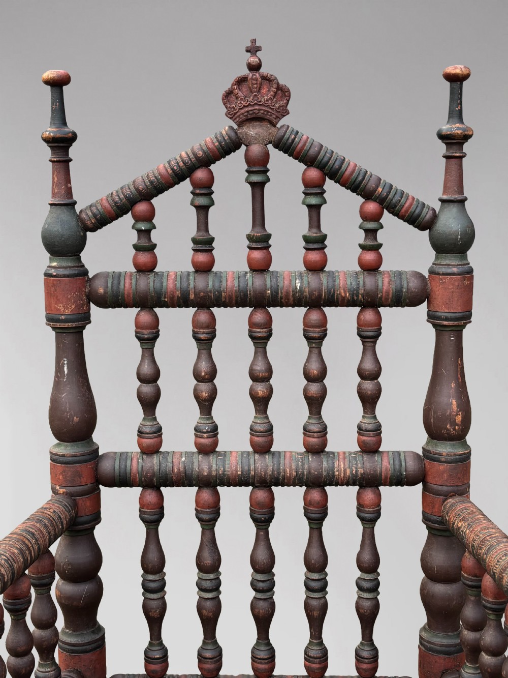A 19th-century Swedish country throne armchair constructed with polychrome turned bobbins, a carved crown top finial, and a light cushion. View IV
