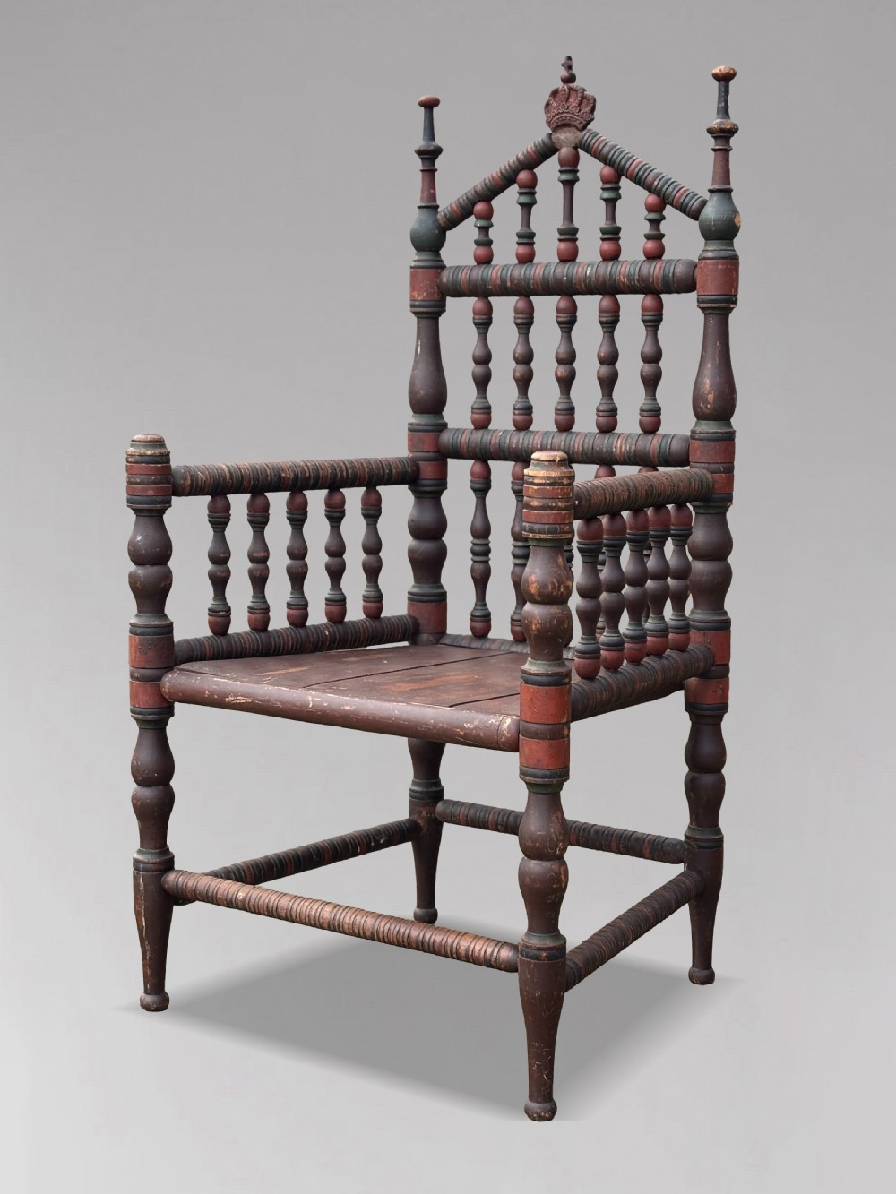 A 19th-century Swedish country throne armchair constructed with polychrome turned bobbins, a carved crown top finial, and a light cushion. View VIII
