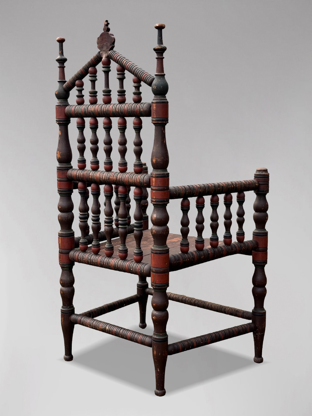 A 19th-century Swedish country throne armchair constructed with polychrome turned bobbins, a carved crown top finial, and a light cushion. View IX