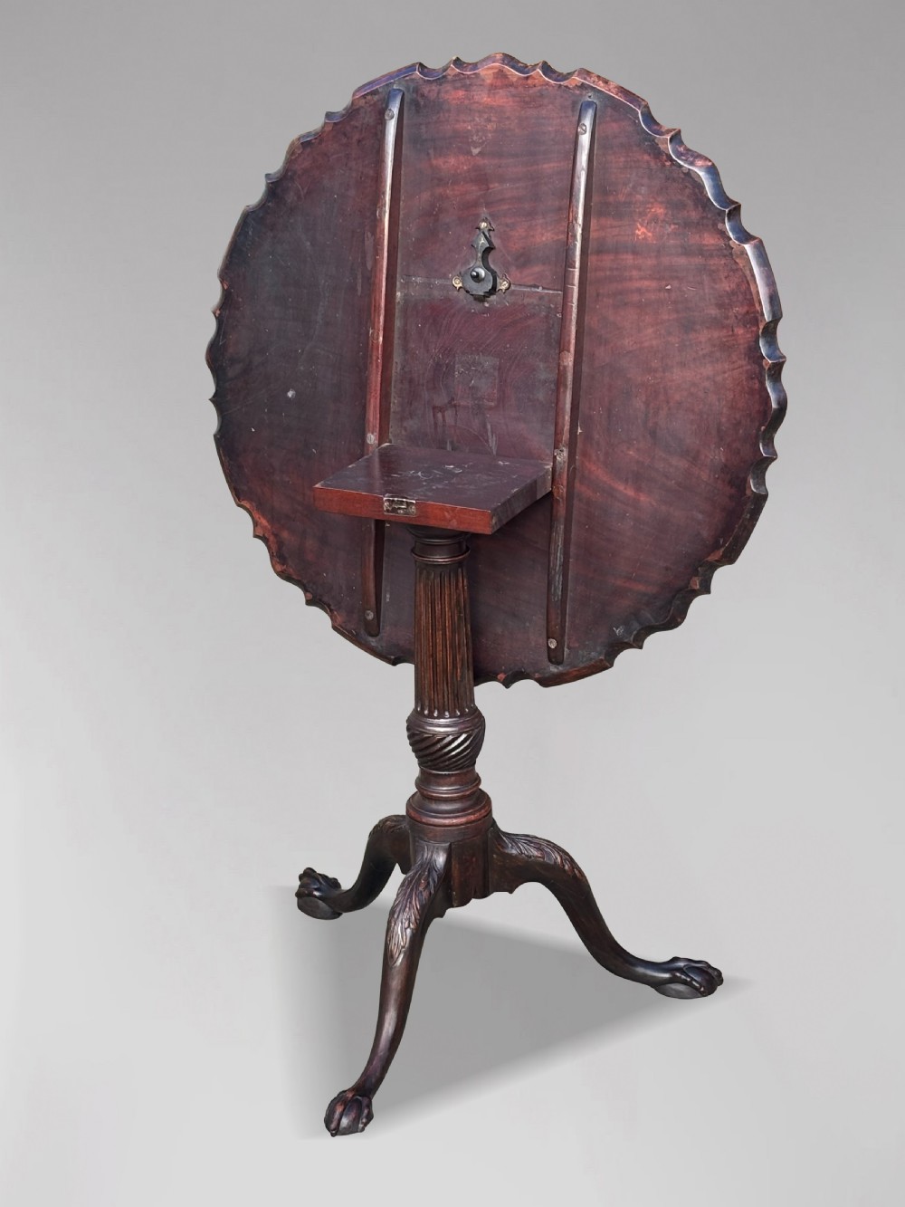 An 18th-century George III mahogany tilt-top tripod table featuring a carved piecrust rim, a fluted column, and cabriole legs ending in claw and ball feet. View IV