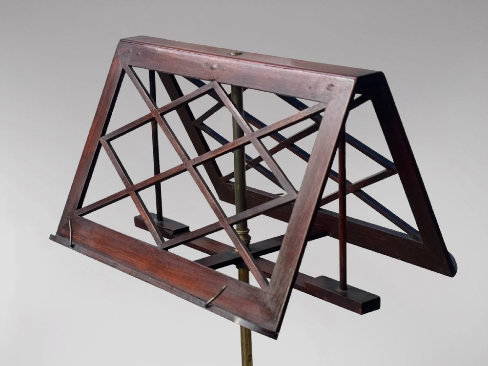 A 19th-century Regency mahogany duet music stand featuring a double-sided lattice desk, adjustable brass column, fluted stem, and tripod base with brass castors. View IV