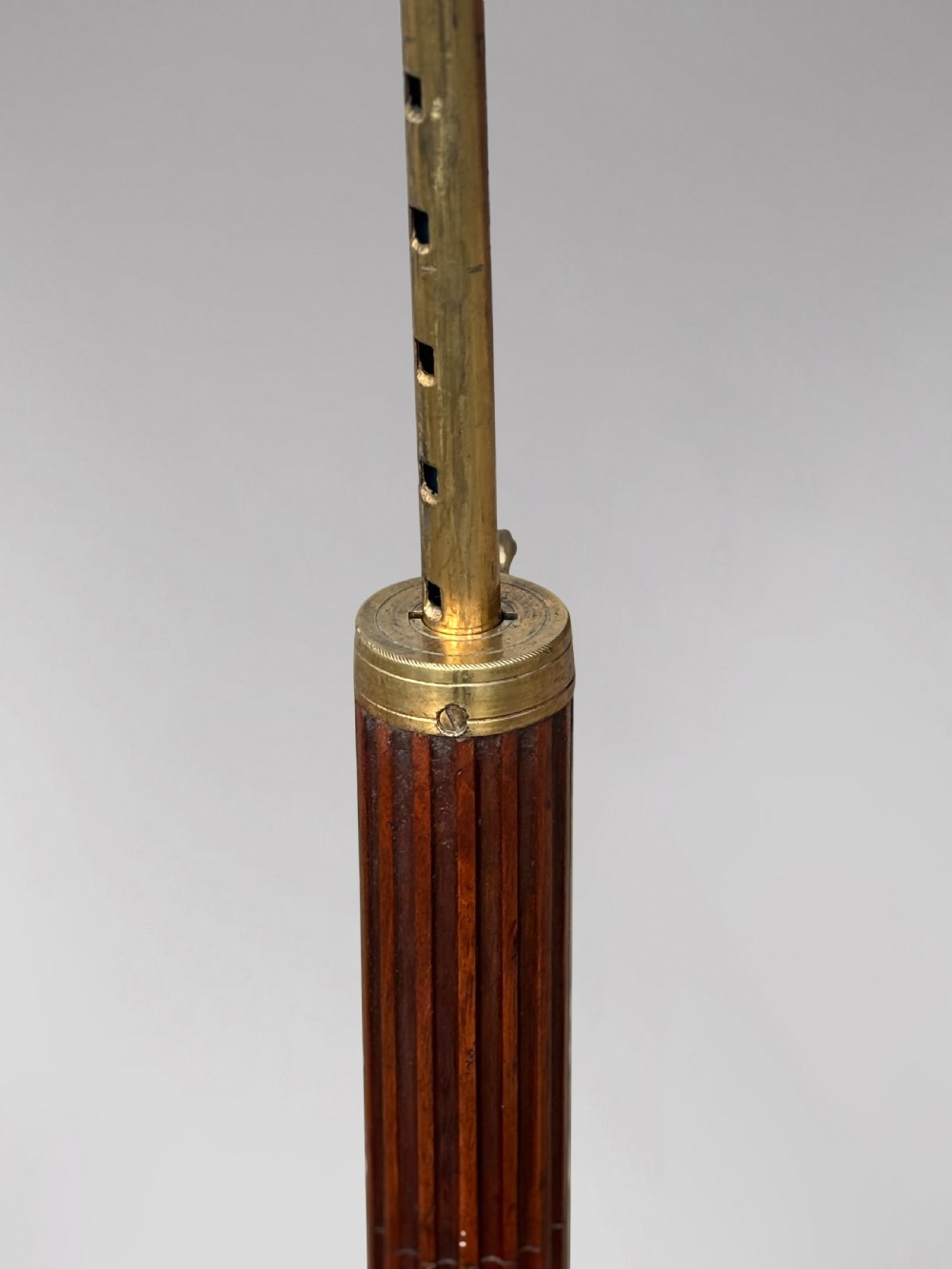 A 19th-century Regency mahogany duet music stand featuring a double-sided lattice desk, adjustable brass column, fluted stem, and tripod base with brass castors. View V